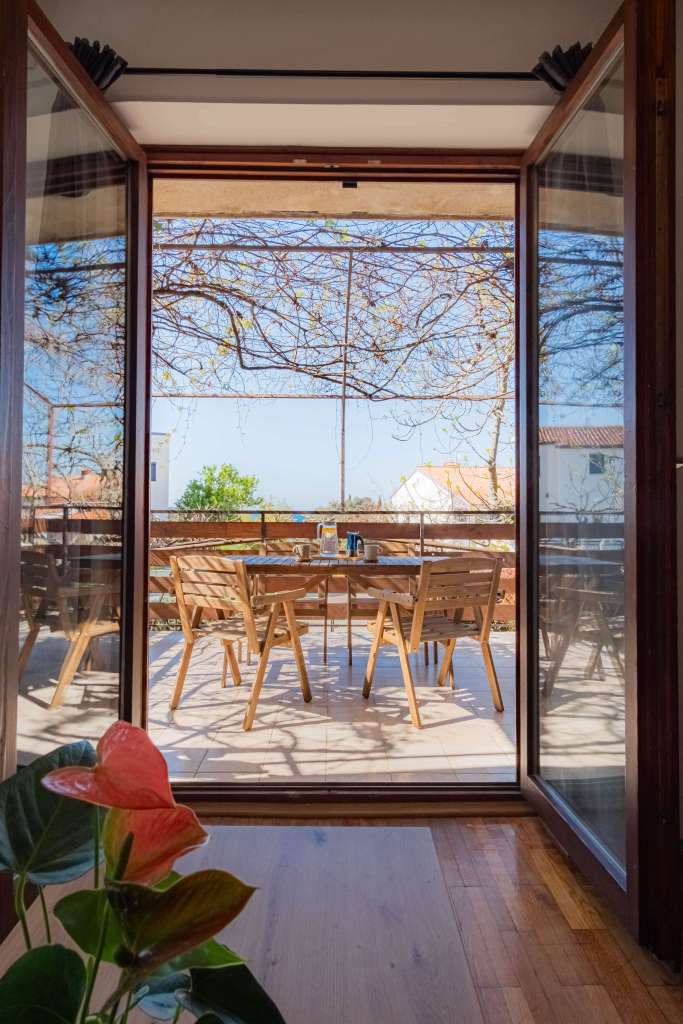 Lampuga Fitness Camp opened window towards sunny balcony used as gathering spot